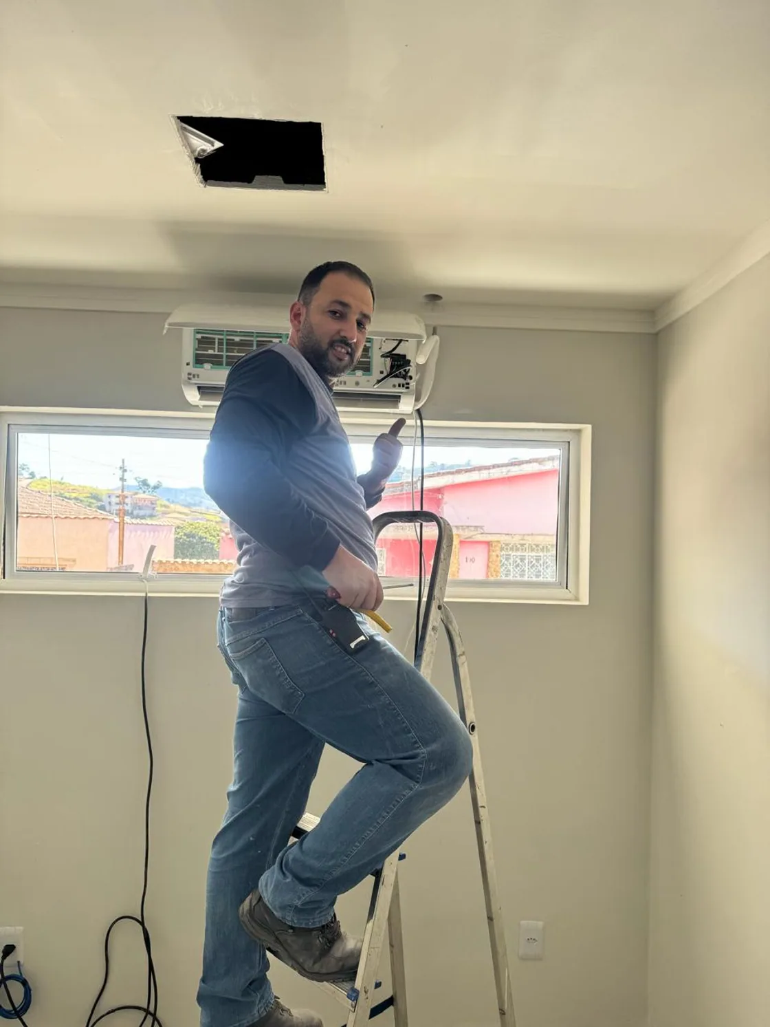 Sidnei, responsável pela Quality Service, instalando uma unidade evaporadora